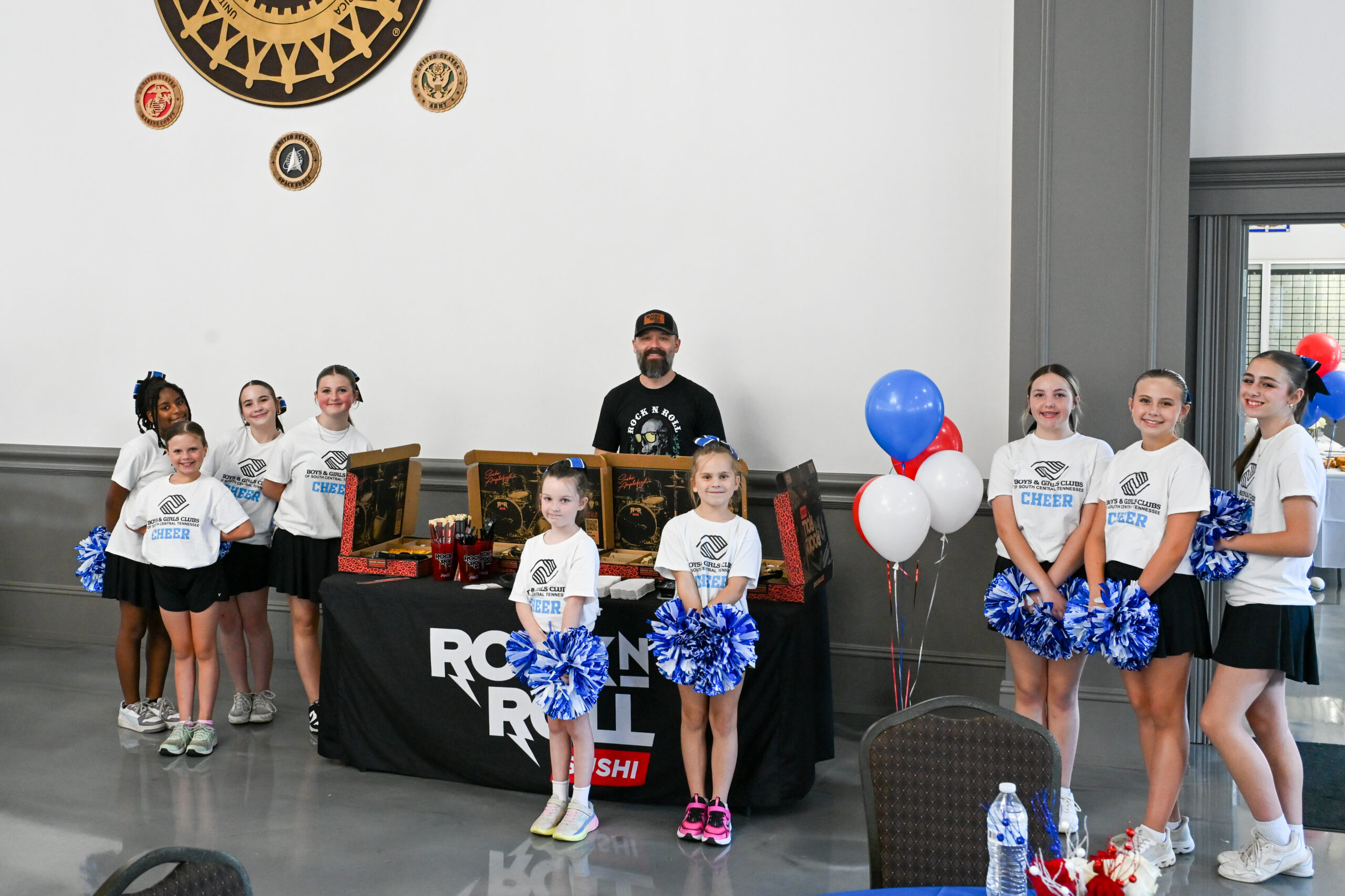 Boys & Girls Club cheerleaders stop for a photo opportunity with Rock N Roll Sushi during the 2026 Spring Hill Hero of the Year Celebration.