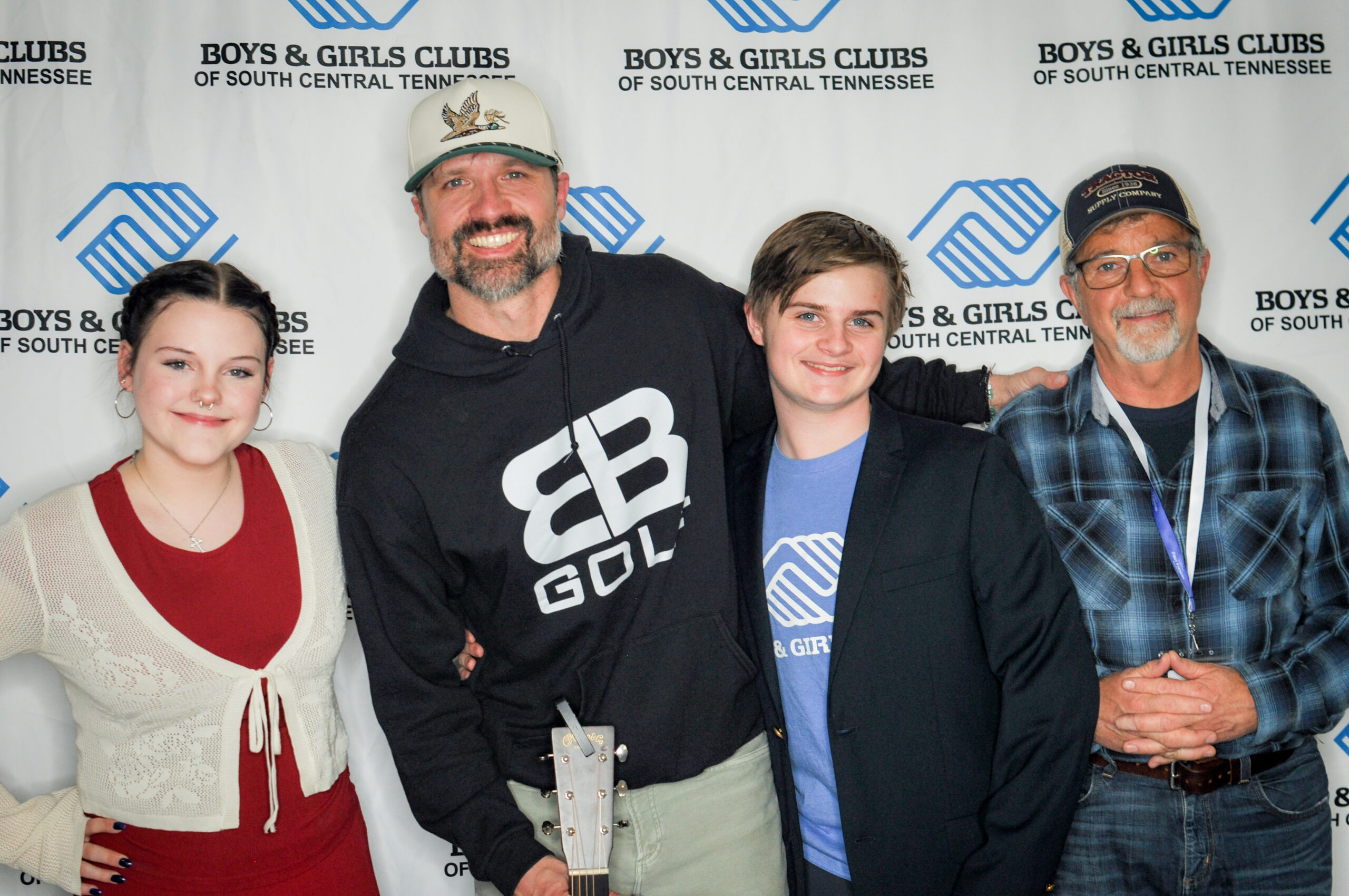 Four people posing in front of a Boys & Girls Clubs backdrop.