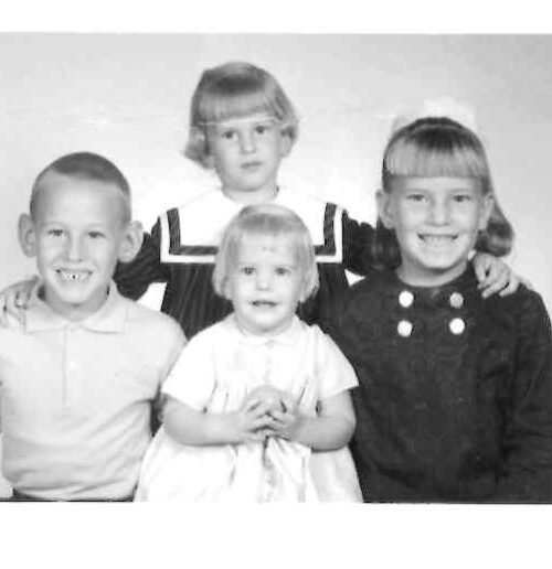 Black and white photo of four children posing together.